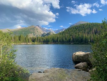 Scenic view of lake by mountains against sky