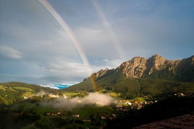 Scenic view of rainbow over mountains against sky