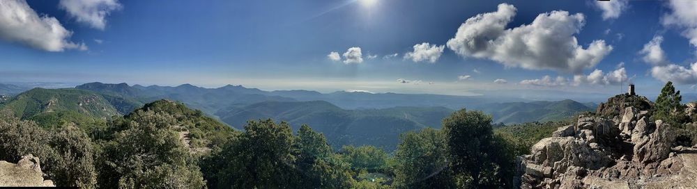 Panoramic view of trees and mountains against sky