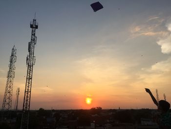 Silhouette of city against sky during sunset