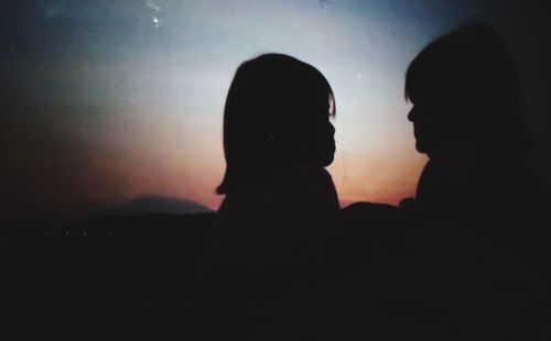 Silhouette friends against sky during sunset