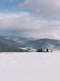 Scenic view of snow covered land against sky