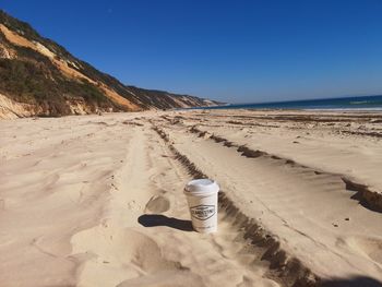 Scenic view of beach against clear blue sky