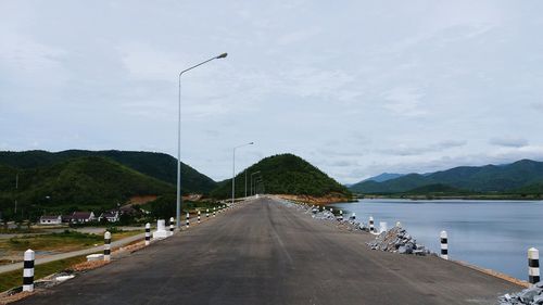 Road by mountain against sky