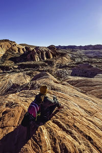 Woman sitting on a rock with a view of valley of fire, nevada