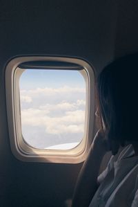 Portrait of woman seen through airplane window