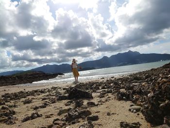 Man standing on beach against sky