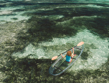 Rear view of woman boating on sea