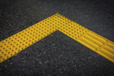 High angle view of yellow sign on road