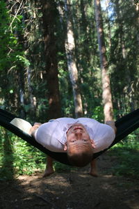 Portrait of man standing by tree in forest