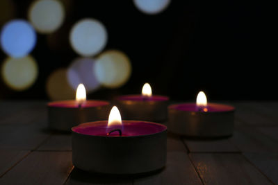 Close-up of illuminated tea light candles on table