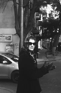 Portrait of man wearing sunglasses standing on street in city