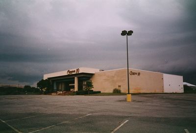 Empty road by building against sky