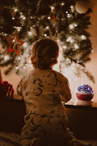 Rear view of boy looking at christmas decoration at home