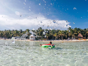 Side view of woman on inflatable ring in sea