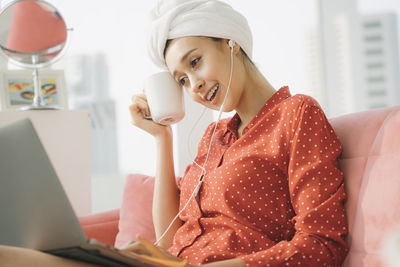 Young woman using mobile phone at home