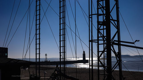 Sailboats moored in sea against sky