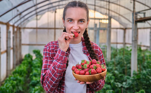 Portrait of young woman picking fruit