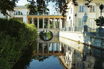 Arch bridge over lake by building