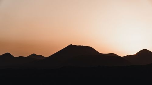 Scenic view of silhouette mountains against clear sky