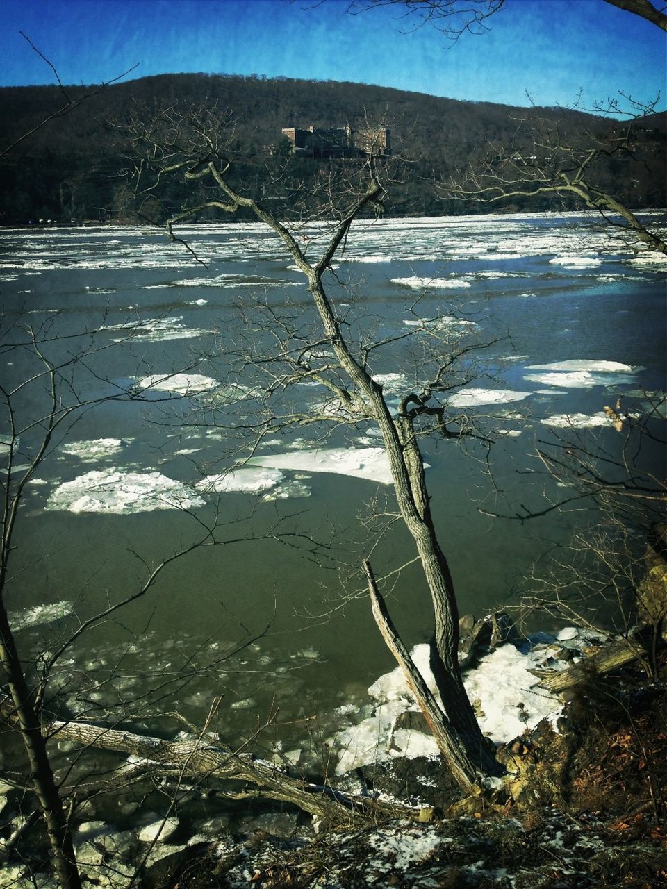 mountain, snow, tranquil scene, tranquility, winter, scenics, water, beauty in nature, cold temperature, nature, mountain range, landscape, bare tree, lake, sky, non-urban scene, season, frozen, sunlight, idyllic