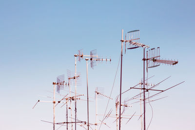 Low angle view of cranes against clear sky