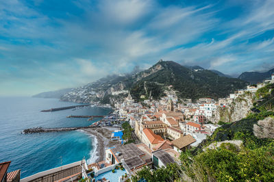 High angle view of townscape by sea against sky