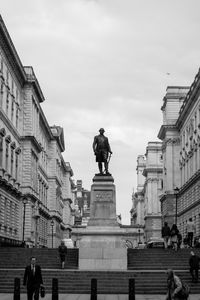 Low angle view of statue amidst buildings