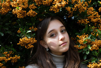 Portrait of beautiful young woman with autumn leaves