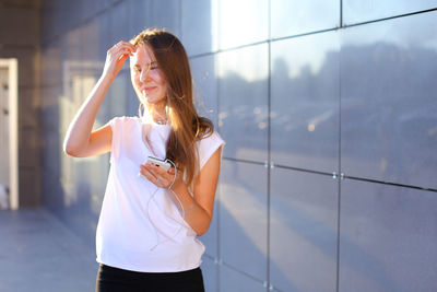 Side view of young woman standing in city