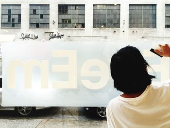 Rear view of man working on advertising banner