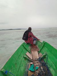 Rear view of man looking at sea against sky