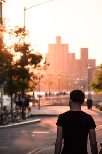 Rear view of man on street against buildings in city