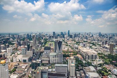 Aerial view of cityscape against cloudy sky