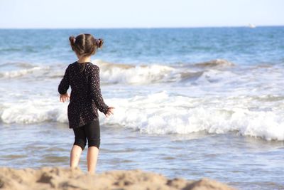 Full length rear view of woman on beach