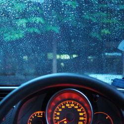 Car seen through wet glass window