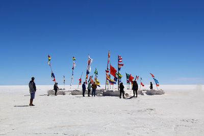 People on beach against clear sky