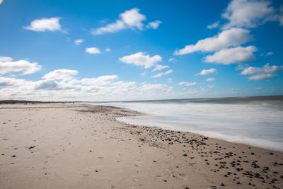 View of calm beach against blue sky