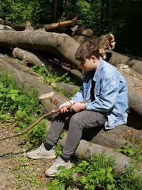 Full length of boy sitting on land