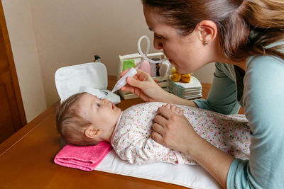 Cute baby holding mother with daughter