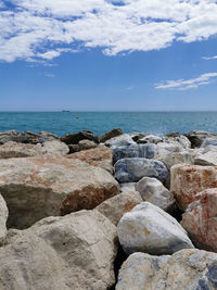 Rocks by sea against sky