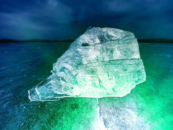 Close-up of ice crystals on sea against sky