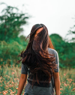 Rear view of woman standing against plants