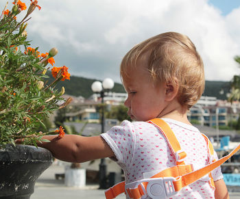 Side view of cute girl holding flowers