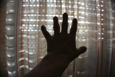 Close-up of hand touching window