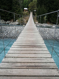 Footbridge over swimming pool against trees