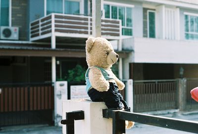 Rear view of woman with toy against building in city