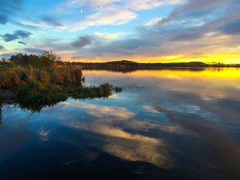 Scenic view of calm lake at sunset