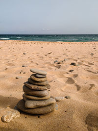 Stack of pebbles on beach against clear sky