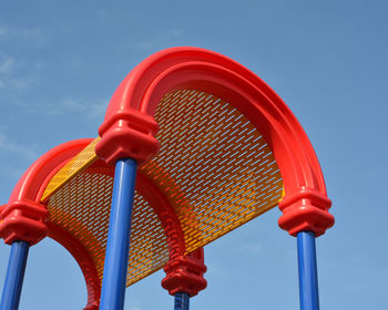Low angle view of red built structure against blue sky